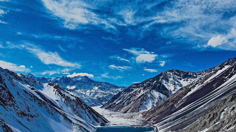 Embalse El Yeso con aguas azul profundo rodeado de montañas nevadas de la cordillera de Los Andes