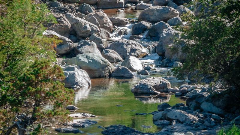 Pozón de aguas cristalinas entre roquerío en el Parque Nacional Río Clarillo, rodeado de bosque nativo