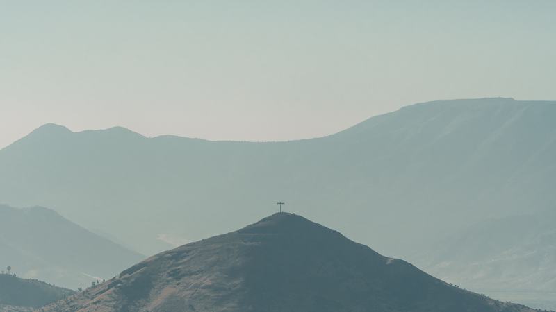 Cima de cerro con cruz, sendero fácil típico de la precordillera de Santiago